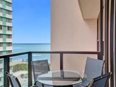 a glass table and chairs on a balcony with the ocean at Comfortable Ocean View Condo Beach Service 1214 in Miami Beach