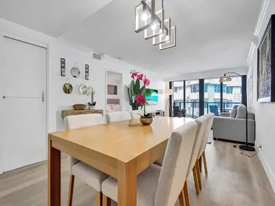 a dining room and living room with a wooden table and chairs at Comfortable Ocean View Condo Beach Service 1214 in Miami Beach