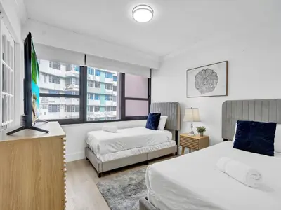 a bedroom with two beds and a flat screen tv at Comfortable Ocean View Condo Beach Service 1214 in Miami Beach