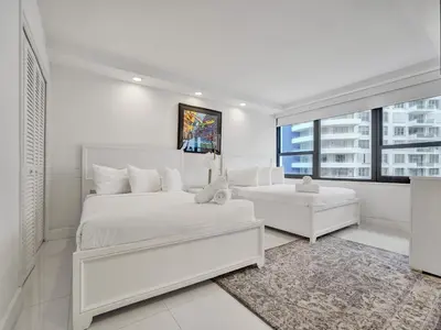 a white bedroom with a white bed and a window at Amazing Ocean View Condo Beach Service 1111 in Miami Beach