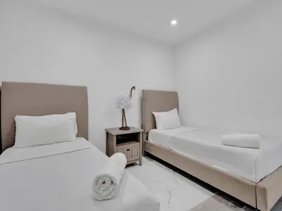 a bedroom with two beds and a night stand with a flower at Ocean View Beachside Bliss Beach Service 1218 in Miami Beach