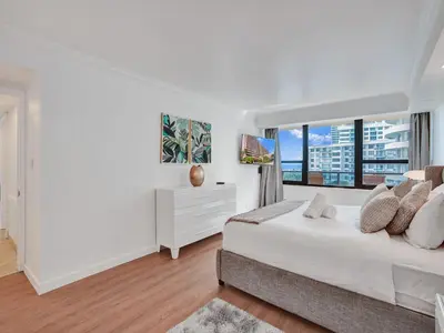 a white bedroom with a bed and a window at Spacious Ocean View Condo Beach Service 803 in Miami Beach