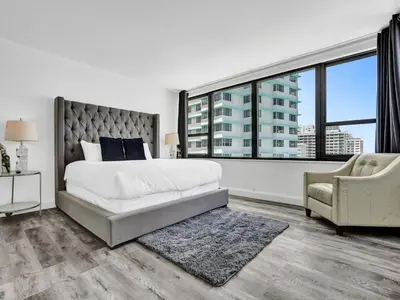 a bedroom with a bed and a large window at Full ocean view Huge private terrace 1002 in Miami Beach