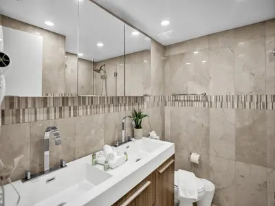 a bathroom with a sink and a toilet and a mirror at Stylish Ocean Beach Retreat Beach Service 1009 in Miami Beach