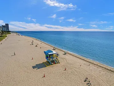 a beach with a life guard stand and people on it at Stylish Ocean Beach Retreat Beach Service 1009 in Miami Beach