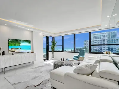 a living room with a white couch and a tv at Luxury Oceanfront Condo Magnificent Views 701 in Miami Beach