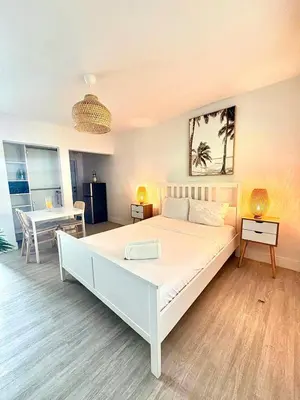 a bedroom with a large white bed and a table at Casa Agave Miami in Miami