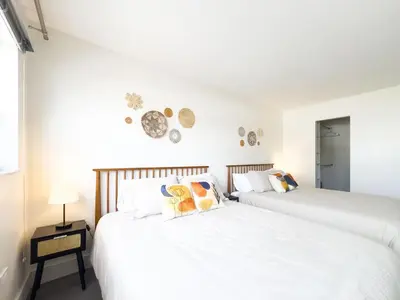 two beds in a bedroom with white walls at The Octagon in South Beach in Miami Beach