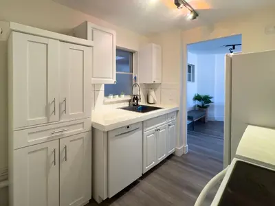 a kitchen with white cabinets and a sink at The Octagon in South Beach in Miami Beach