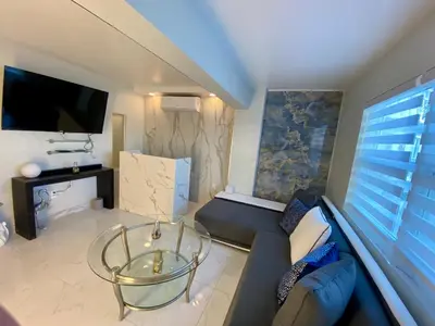 a living room with a couch and a glass table at Luxurious remodeled direct Waterfront apartment with Miami skyline view- Free parking- 5min drive to Miami Beach in Miami Beach