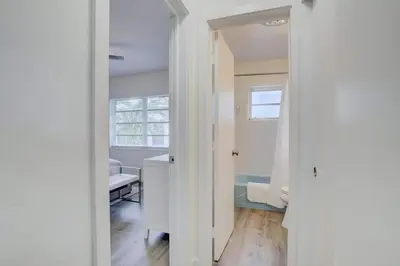 a white room with a bed and a window at Pool Access Free Parking Smart TV Wifi in Fort Lauderdale