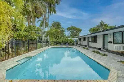 a swimming pool in the backyard of a house with palm trees at Pool Access Free Parking Smart TV Wifi in Fort Lauderdale