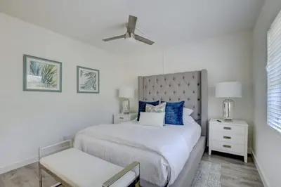 a white bedroom with a large bed with blue pillows at Pool Free Wifi Parking Smart TV in Fort Lauderdale