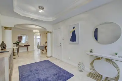 a large living room with a blue rug and a mirror at Private Patio Cali King Bed Walk to Las Olas in Fort Lauderdale