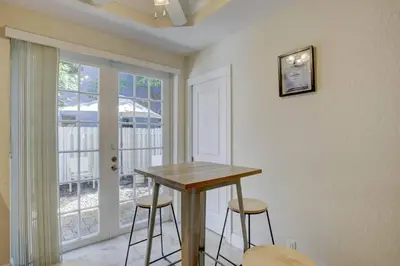 a table and two stools in a room with a window at Private Patio Cali King Bed Walk to Las Olas in Fort Lauderdale
