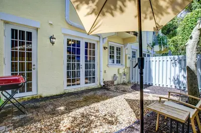 a patio with a bench and an umbrella at Private Patio Cali King Bed Walk to Las Olas in Fort Lauderdale