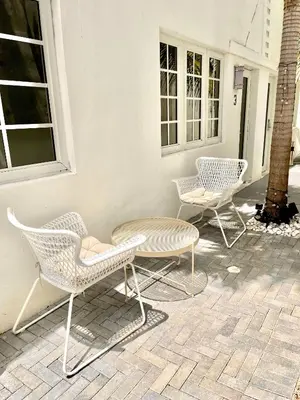 a group of chairs and a table on a patio at 12 GUESTS LUXURIOUS SOUTH BEACH SUITE 2 in Miami Beach
