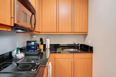 a kitchen with wooden cabinets and a sink at 1435 Brickell Ave 3004 in Miami