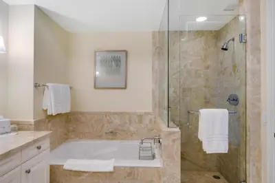 a bathroom with a tub and a glass shower at 1435 Brickell Ave 3004 in Miami
