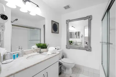 a bathroom with a sink and a toilet and a mirror at Spacious 2 Bed Unit in Brickell with Free Parking in Miami