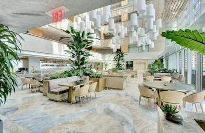 a lobby with tables and chairs and plants at Brickell 31th Floor Sea View Free Parking by Palermo Home Miami in Miami