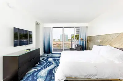 a bedroom with a large bed and a large window at 2BR W Residence, FLL Beach, Oceanside, pools, hot tub, bar credit in Fort Lauderdale