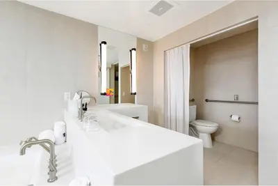 a white bathroom with a sink and a toilet at 2BR W Residence, FLL Beach, Oceanside, pools, hot tub, bar credit in Fort Lauderdale