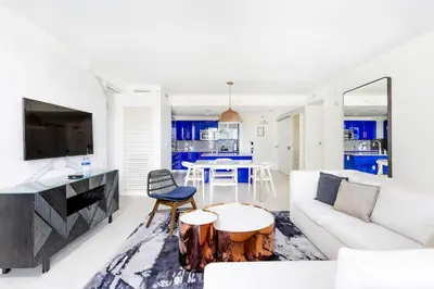 a living room with a white couch and a table at 2BR W Residence, FLL Beach, Oceanside, pools, hot tub, bar credit in Fort Lauderdale