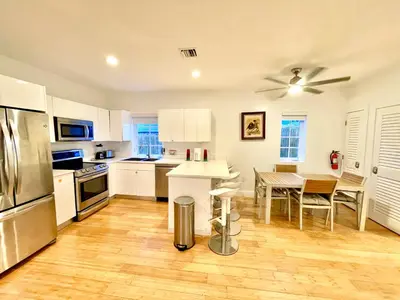 a kitchen with white cabinets and a table in it at 20 GUESTS LUXURIOUS SOUTH BEACH SUITE 2 in Miami Beach