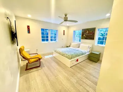 a bedroom with a bed and a yellow chair at 60 Guests Luxury South Beach Private Estate in Miami Beach
