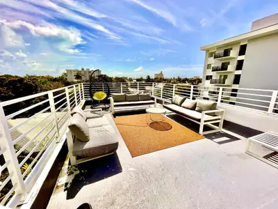 a balcony with couches and a table on a building at 60 Guests Luxury South Beach Private Estate in Miami Beach