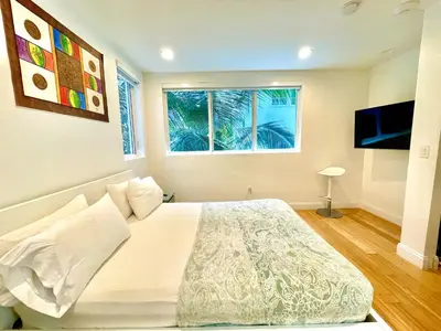 a bedroom with a large white bed with a window at 60 Guests Luxury South Beach Private Estate in Miami Beach