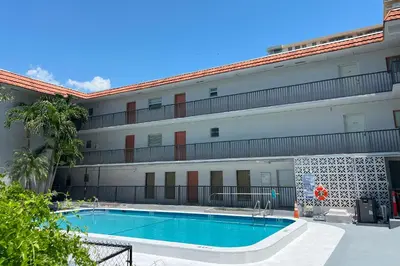 a hotel with a swimming pool in front of a building at Sunny Isles Apartments by MiaRentals in Sunny Isles Beach