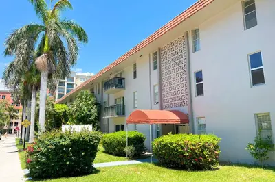 a building with a palm tree and a building at Sunny Isles Apartments by MiaRentals in Sunny Isles Beach