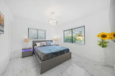 a bedroom with a bed and a vase of flowers at Luxury Villa Azure with Heated Pool 20 minutes to Beach in Miami