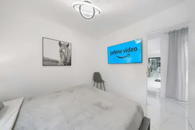 a white bedroom with a bed and a chair at Luxury Villa Azure with Heated Pool 20 minutes to Beach in Miami