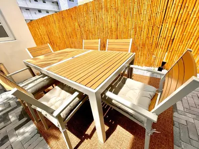 a wooden table and chairs on a patio at 30 GUESTS LUXURY SOUTH BEACH SUITES w ROOFTOP in Miami Beach