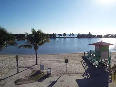 a beach with a lifeguard tower and a body of water at Free BBQ in RV With Private entrance in Homestead