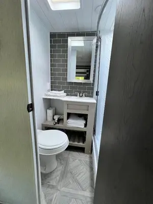 a bathroom with a toilet and a sink and a mirror at Free BBQ in RV With Private entrance in Homestead