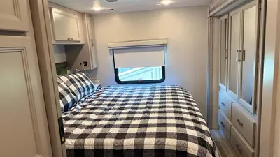 a bed in a small room with a window at Private Cozy R/V , for your enjoyment in Tamiami