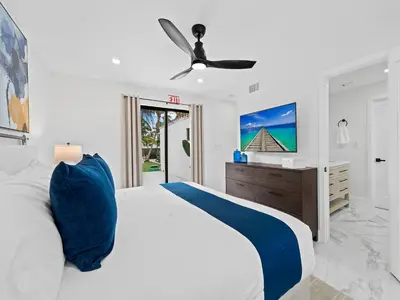 a white bedroom with a bed and a ceiling fan at Spacious home w heated pool jacuzzi in Hollywood