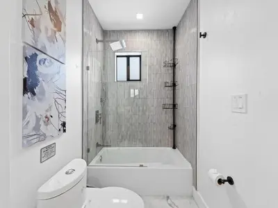 a white bathroom with a tub and a toilet at Spacious home w heated pool jacuzzi in Hollywood