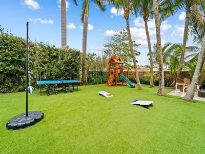 a yard with a playground with palm trees at Spacious home w heated pool jacuzzi in Hollywood