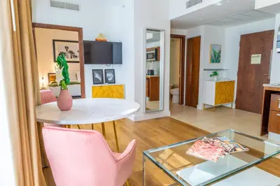 a living room with a pink chair and a glass table at 1-Bed Apt with rooftop pool Ocean Dr by the Beach B207 in Miami Beach