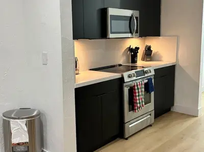 a kitchen with a stove and a microwave at Sri House in Miami