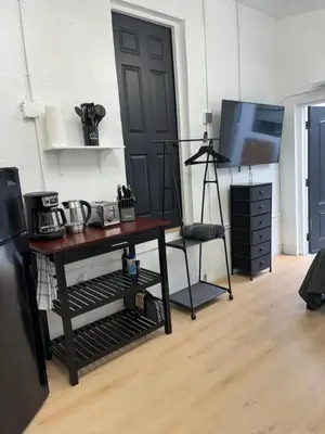 a room with a table and a black door and a television at Sri House in Miami