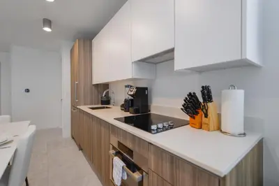 a kitchen with white cabinets and a black counter top at Prime location: Luxury Condo at brickell in Miami