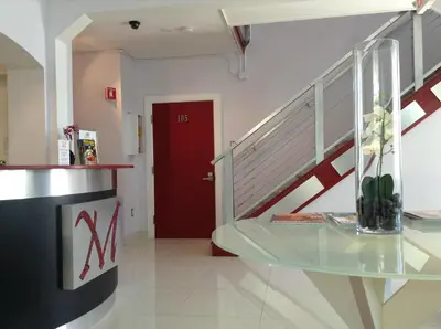a hallway with a glass table and a red door at M HOTEL in Miami Beach