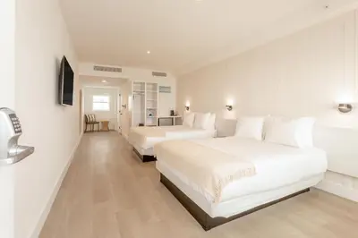 two beds in a hotel room with white walls at Casa SOBE in Miami Beach