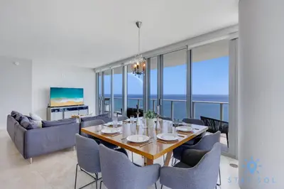 a dining room with a table and chairs and a couch at Oceanview Luxury 3BR Sky Home Amaizing Pool in Hollywood